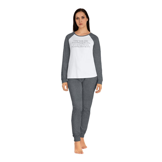 Woman standing in a white and gray raglan sleeve shirt and matching gray leggings designed as "I may look like I'm listening to you, but..." pajamas.