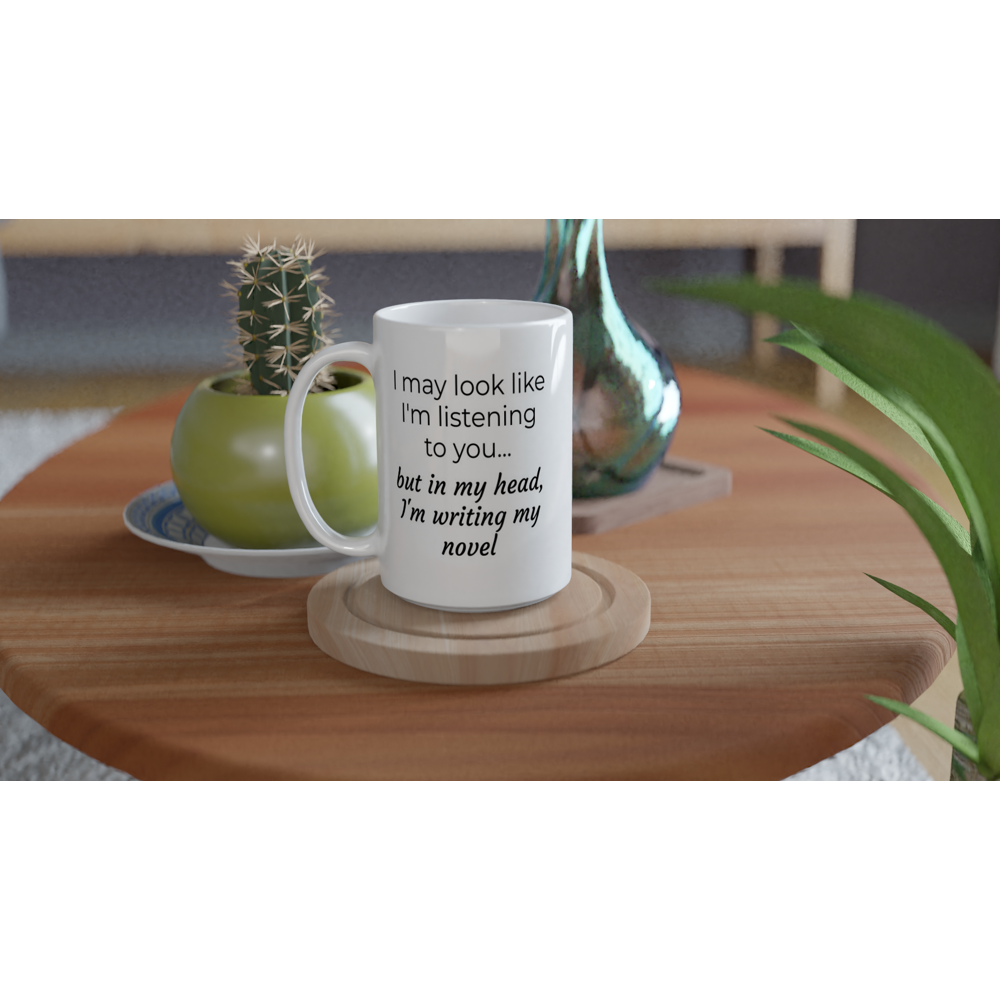 A white coffee "I may look like I'm listening to you, but in my head I'm writing my novel // Writing Themed Mug" on a table with a plant on it, perfect for writer's coffee break while writing my novel.